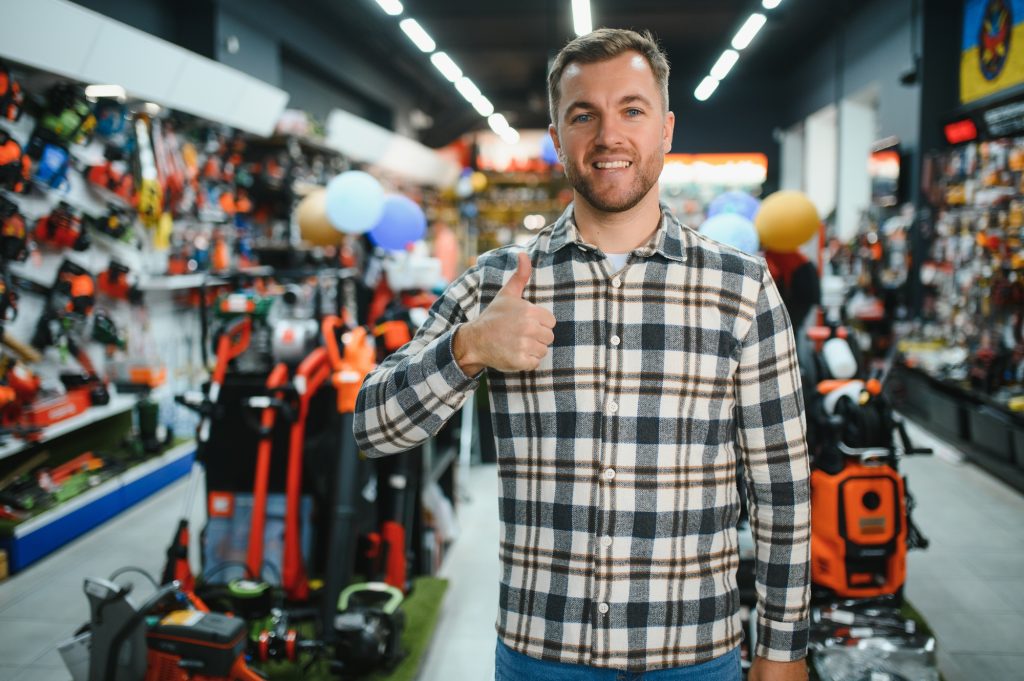 A man in a hardware store choosing a tool
